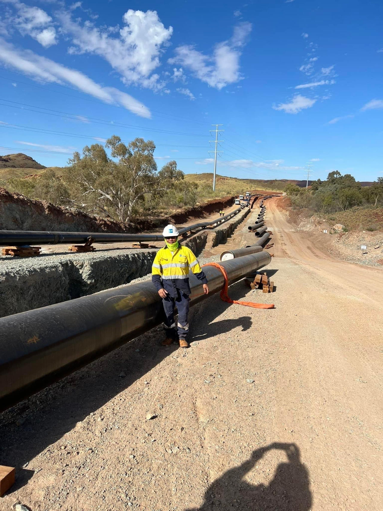 Tradesperson beside a large-diameter pipeline